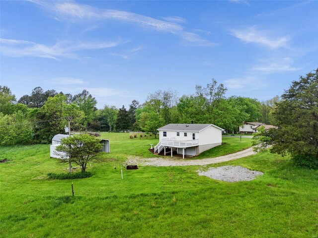 view of yard with driveway and a deck