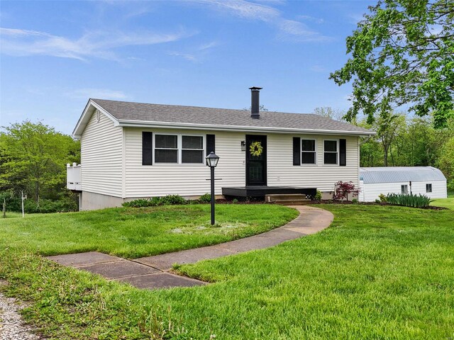 ranch-style house with roof with shingles and a front yard