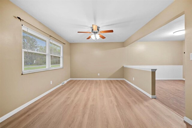 unfurnished room with baseboards, ceiling fan, and light wood-type flooring