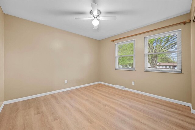 unfurnished room featuring a ceiling fan, baseboards, visible vents, and light wood finished floors