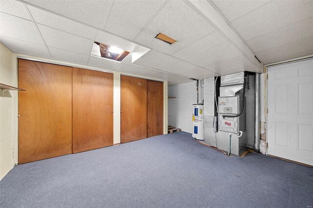 finished below grade area featuring heating unit, carpet, water heater, and a drop ceiling