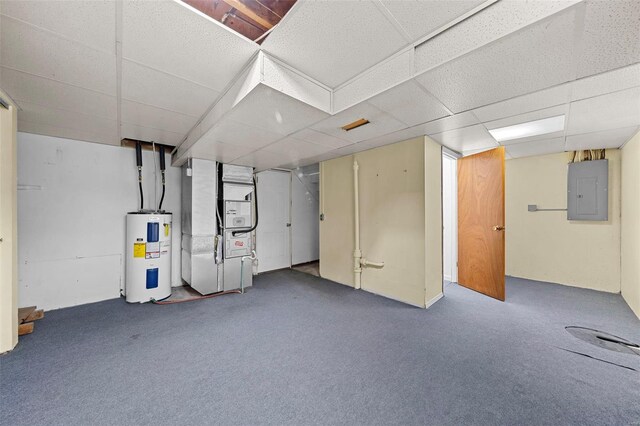 finished below grade area with electric panel, a paneled ceiling, water heater, heating unit, and carpet