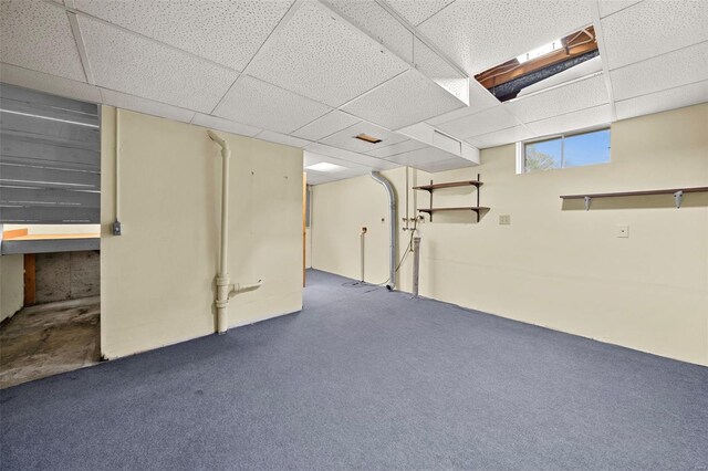 basement featuring a drop ceiling and carpet