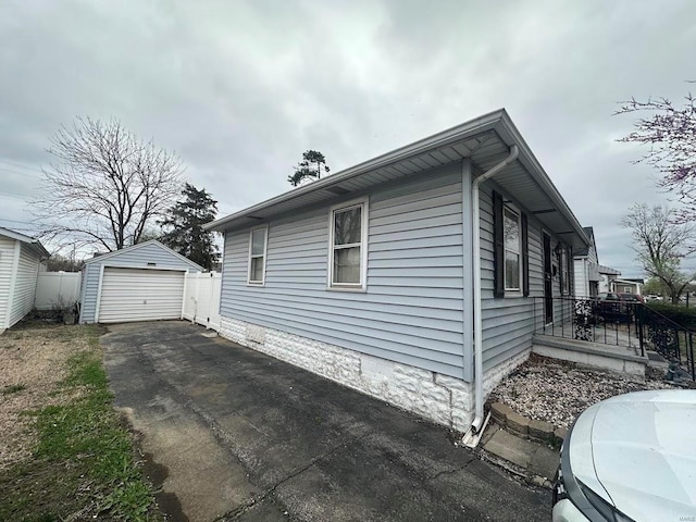 view of property exterior with an outbuilding, driveway, and a garage