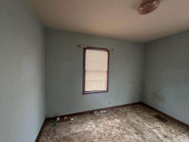 empty room featuring carpet, visible vents, and baseboards