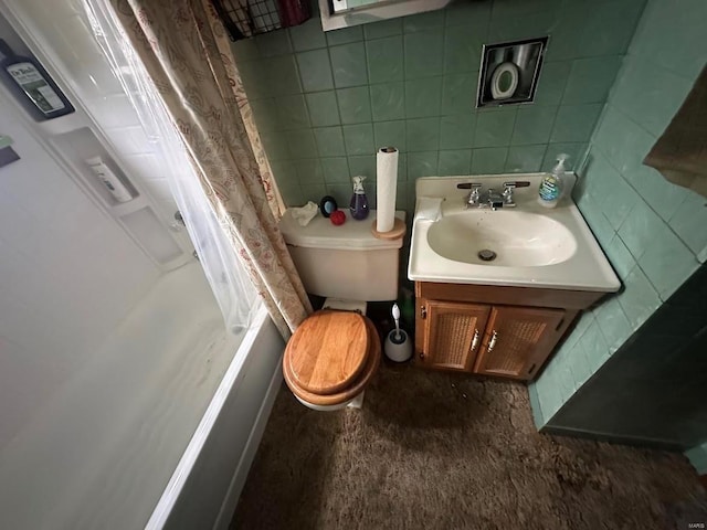 bathroom with shower / tub combo, vanity, toilet, and tile walls