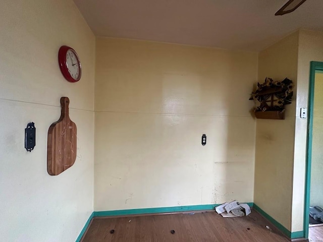 laundry room featuring wood finished floors and baseboards