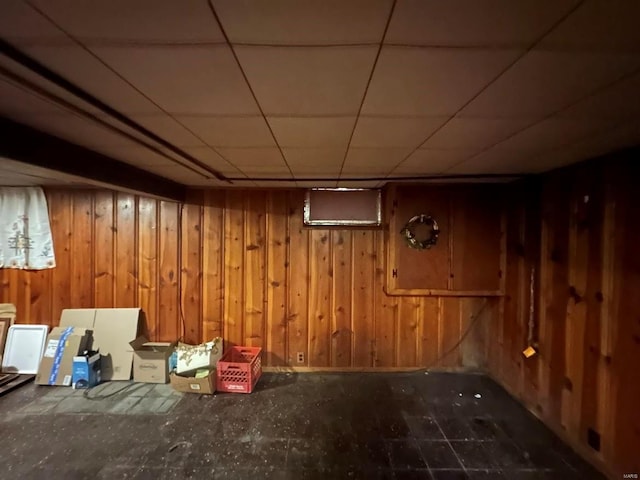 finished below grade area featuring wooden walls and a drop ceiling