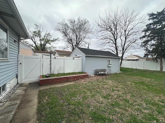 view of yard with an outbuilding, fence, and a gate