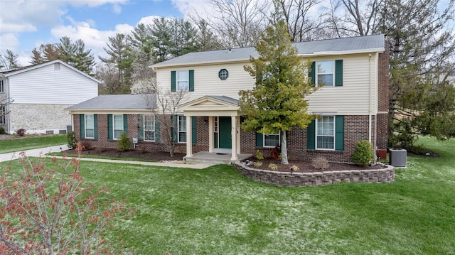 view of front of house with brick siding, central AC unit, and a front yard
