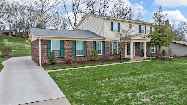traditional home featuring brick siding, a front lawn, and concrete driveway