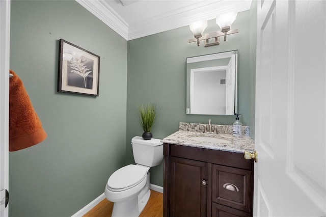 bathroom featuring crown molding, vanity, wood finished floors, toilet, and baseboards