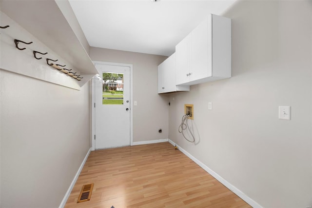 clothes washing area featuring cabinet space, electric dryer hookup, light wood finished floors, and hookup for a washing machine