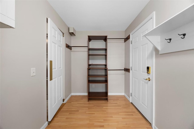 walk in closet with light wood-style floors