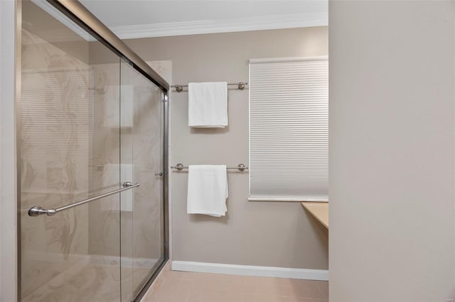 bathroom featuring baseboards, tile patterned flooring, crown molding, and a stall shower