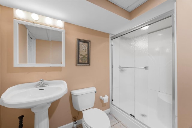 bathroom featuring toilet, baseboards, tile patterned flooring, and a stall shower