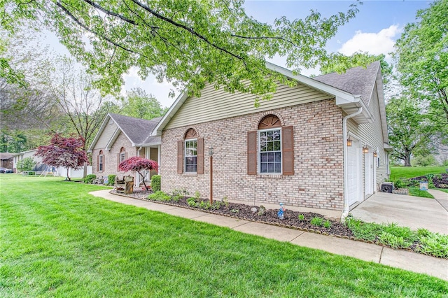 single story home with concrete driveway, a front yard, brick siding, and a garage