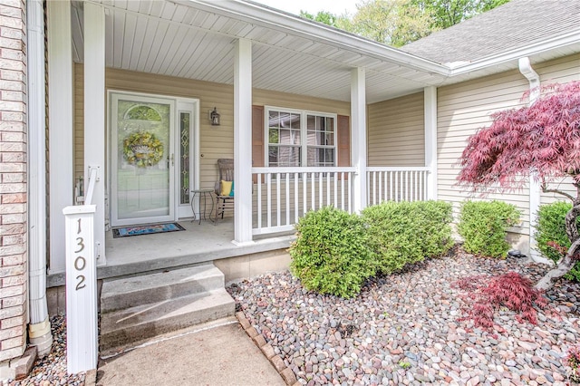 property entrance featuring a porch and a shingled roof