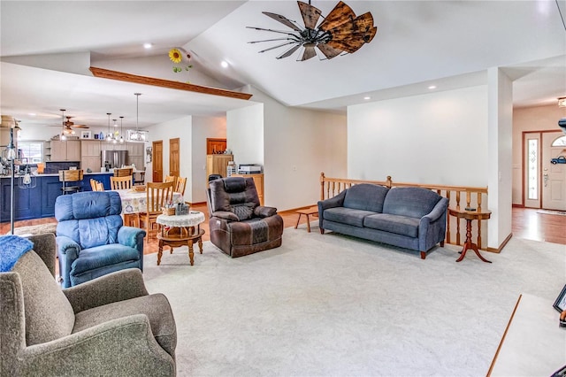 living room featuring lofted ceiling, a wealth of natural light, a ceiling fan, and carpet floors