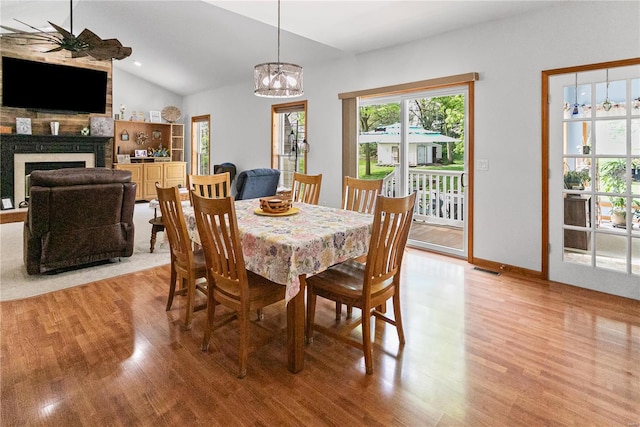 dining room with light wood finished floors, a wealth of natural light, and ceiling fan with notable chandelier
