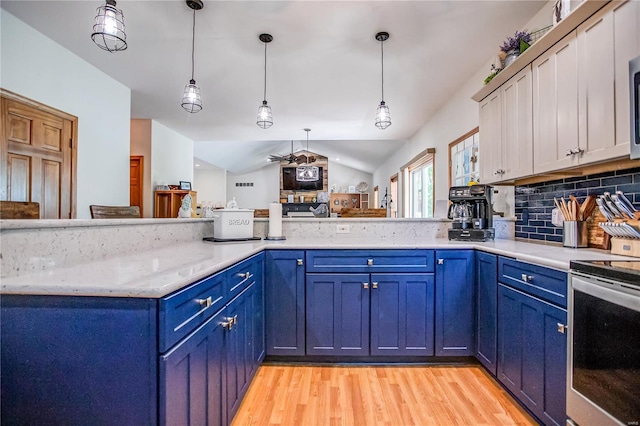 kitchen featuring blue cabinetry, stainless steel appliances, decorative backsplash, and light wood-style flooring