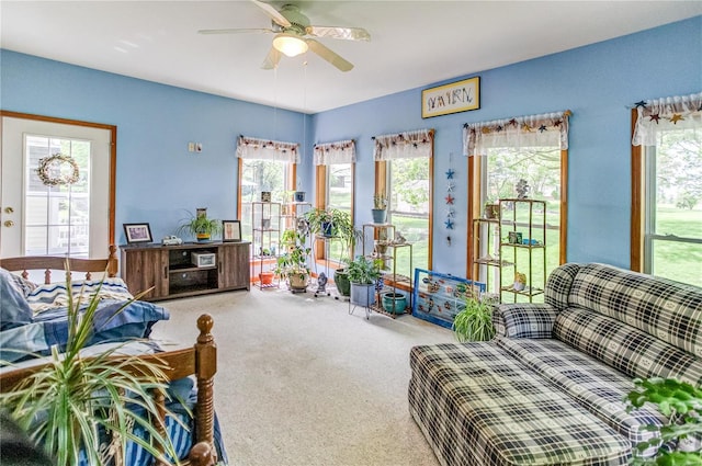 carpeted living area featuring a ceiling fan