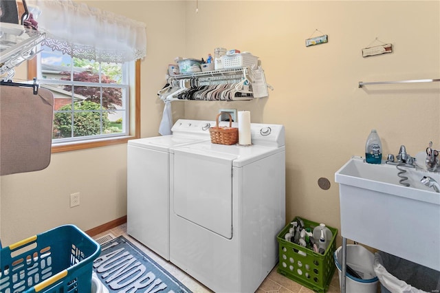 laundry area featuring washing machine and clothes dryer, laundry area, and a sink
