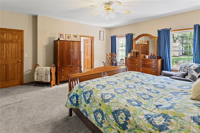 carpeted bedroom with ceiling fan and multiple windows