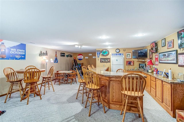 dining area featuring recessed lighting, light carpet, and indoor wet bar