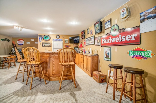 bar featuring recessed lighting, indoor wet bar, and light colored carpet