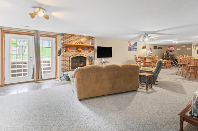 carpeted living area with visible vents, ceiling fan, and a brick fireplace