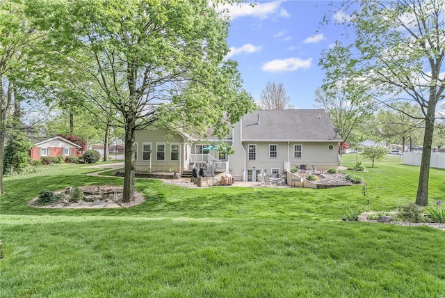 back of house with a lawn and a patio