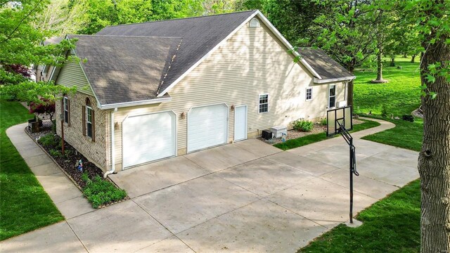 view of side of property featuring a lawn and roof with shingles