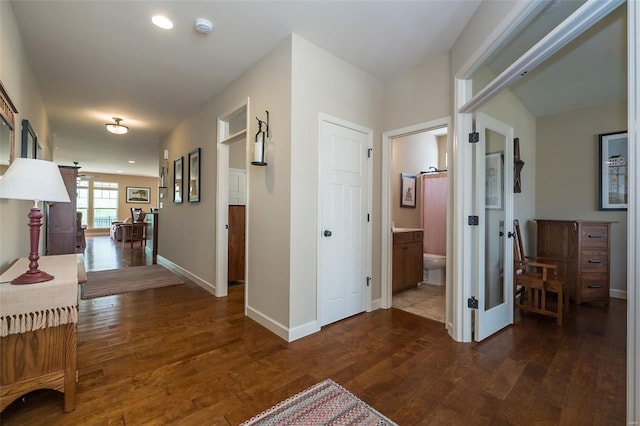 corridor with dark wood-style flooring, baseboards, recessed lighting, and french doors