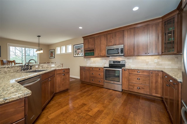 kitchen featuring a sink, decorative backsplash, dark wood-style floors, and stainless steel appliances