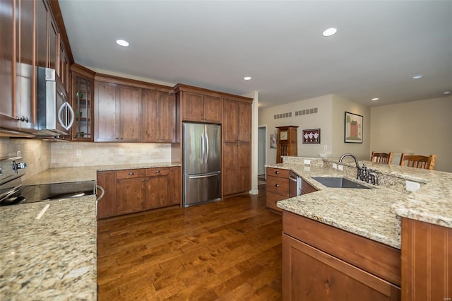 kitchen featuring dark wood-type flooring, a sink, decorative backsplash, and stainless steel appliances