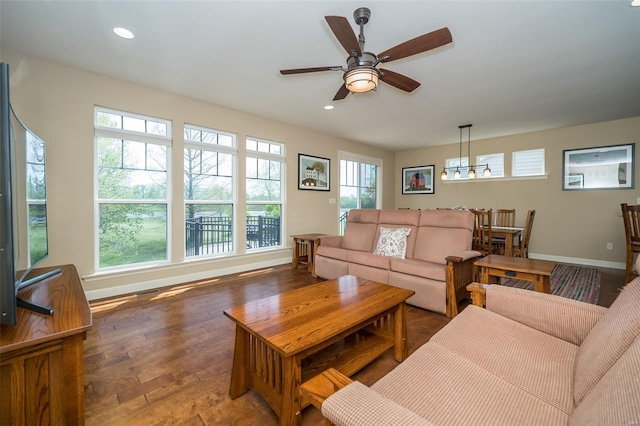 living area featuring baseboards, ceiling fan with notable chandelier, recessed lighting, and wood finished floors