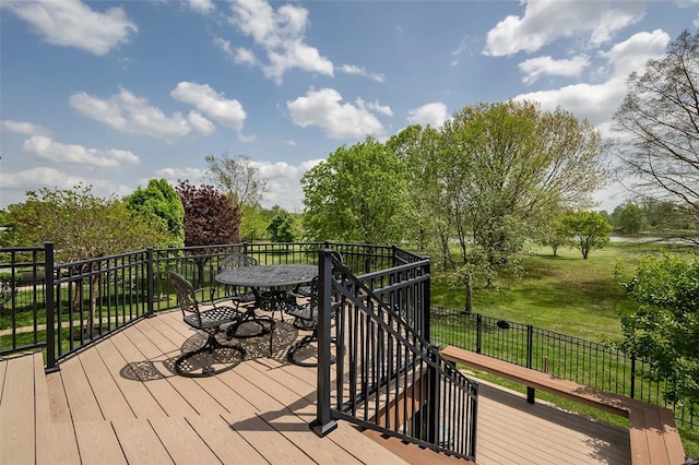 wooden terrace with a yard and outdoor dining area