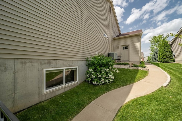 view of side of home with central air condition unit and a lawn
