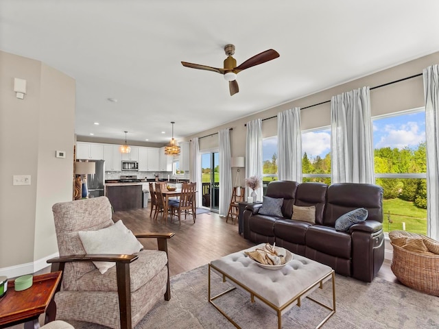 living room with light wood-style floors, ceiling fan, and recessed lighting