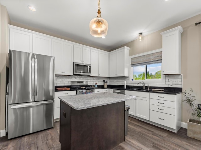 kitchen featuring a sink, decorative backsplash, stainless steel appliances, and dark wood finished floors