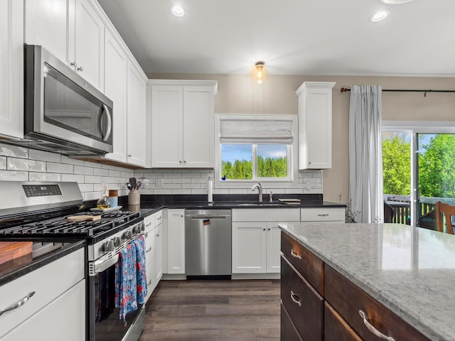 kitchen featuring white cabinets, appliances with stainless steel finishes, and a healthy amount of sunlight