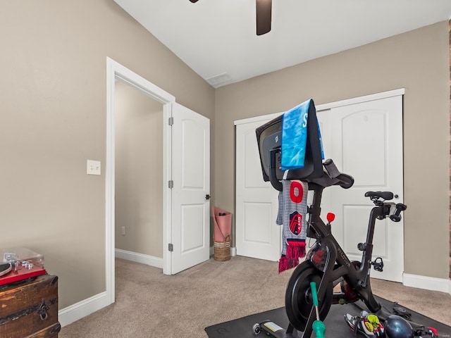 exercise room with baseboards, ceiling fan, and carpet