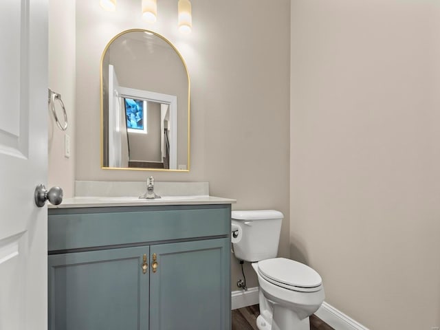 bathroom featuring vanity, baseboards, toilet, and wood finished floors