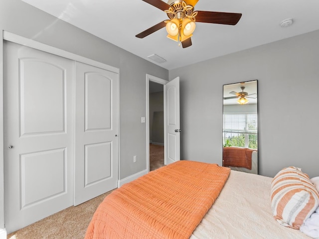 carpeted bedroom featuring a ceiling fan, visible vents, and a closet