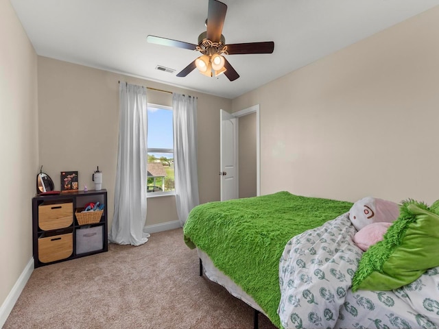 carpeted bedroom with baseboards, a ceiling fan, and visible vents
