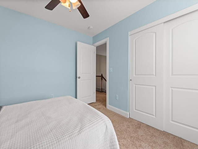 bedroom featuring carpet flooring, a ceiling fan, baseboards, and a closet