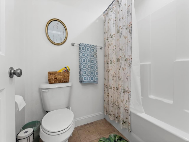 full bath featuring baseboards, shower / bath combo, and toilet