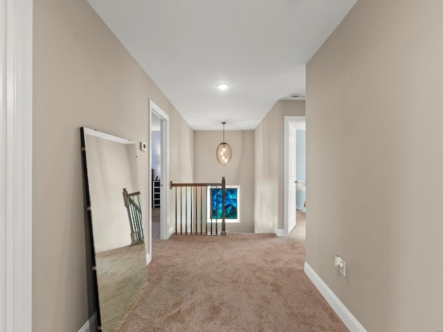corridor featuring carpet floors and an upstairs landing