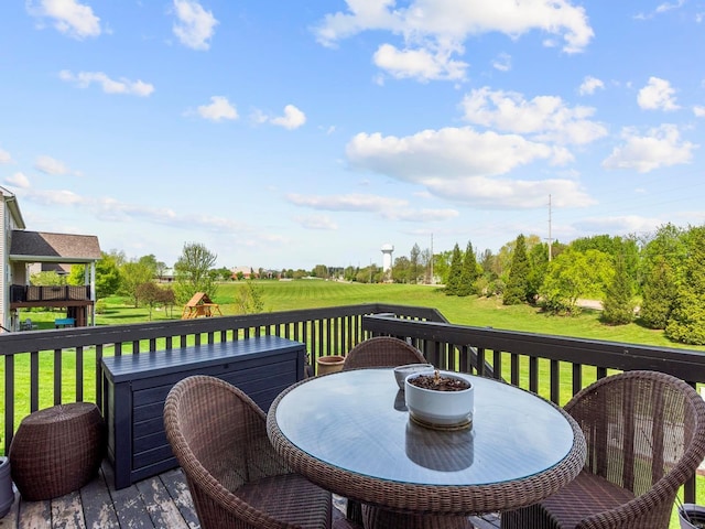 wooden terrace with a lawn and outdoor dining space